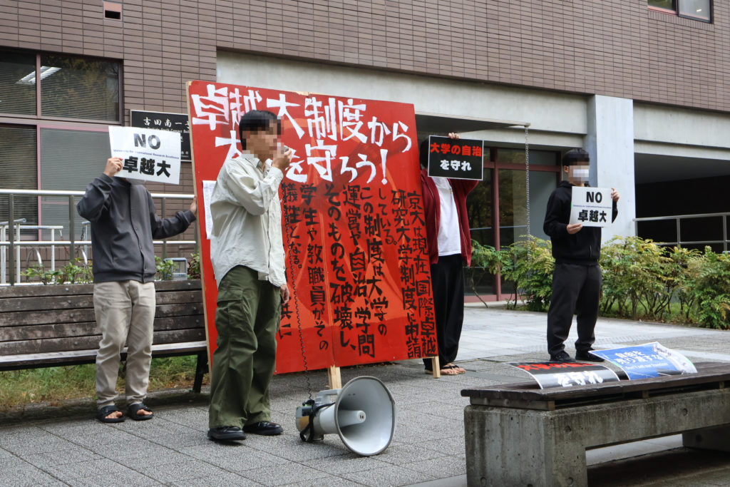 学生有志が卓越大反対スタンディング　「全構成員との対話を」と訴え